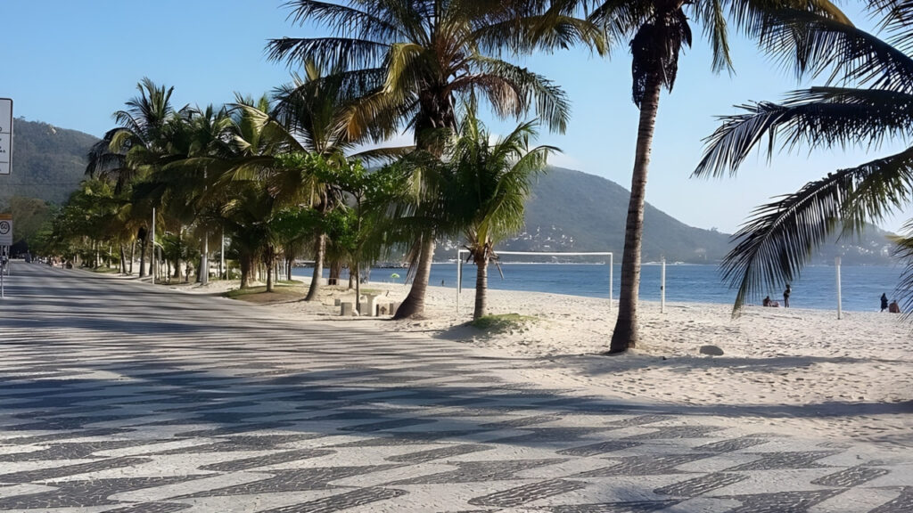 Praia de São Francisco em Niterói, com calçadão arborizado, areia clara e mar tranquilo
